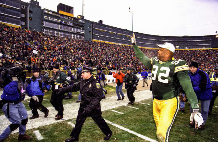 Packers legend Reggie White waves to the crowd as he leaves Lambeau Field